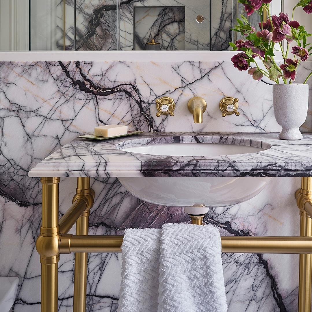 Ball style Sinklegs, shown in satin brass, with purple veined marble backdrop